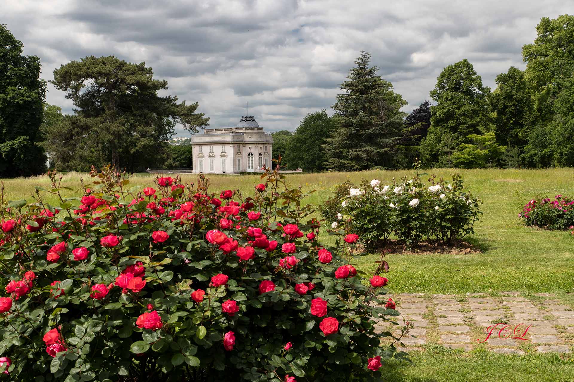 Le Château avec en premier plan parterre de roses rouges.	
