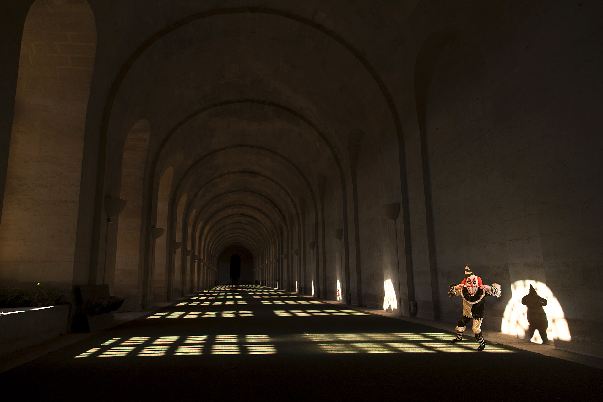 Le Clown dans l'Orangerie du Château de Versailles à la lumière du soleil traversant les fenêtres.